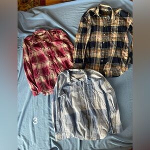Three women’s long sleeve button front shirts.